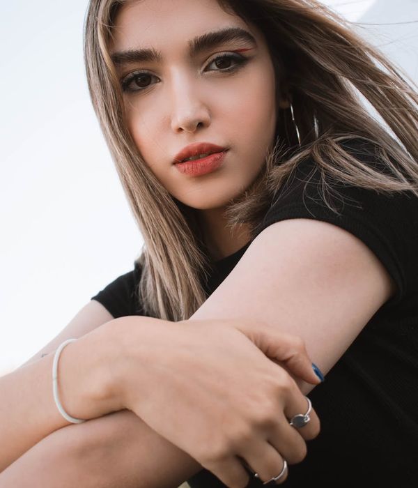 Woman in a calm yoga pose on a light blue background.